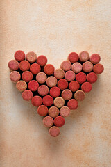 Heart made of wine bottle corks on textured table, top view
