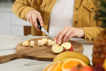 Obraz premium Woman preparing ingredients for tasty smoothie at white marble table in kitchen, closeup