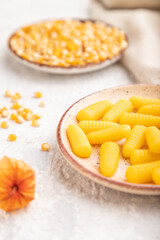 Jelly corn candies on gray concrete background. close up, side view, selective focus.