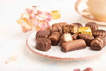 Chocolate candies with cup of coffee. side view, selective focus.