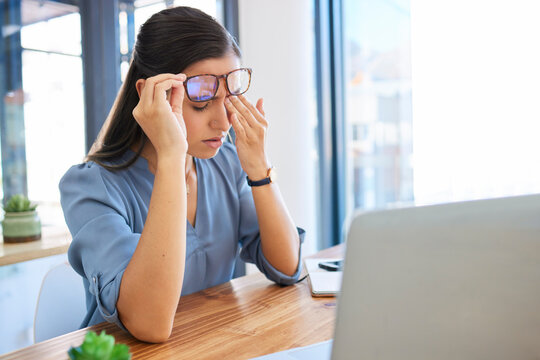 Woman headache, office and tired with laptop, glasses and fatigue of eyes, pain or stress at workplace table. Finance expert, rest and burnout at desk, computer and modern office in city of New York