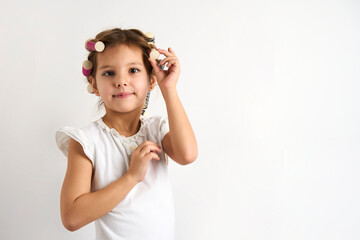 Little girl with curlers on white background