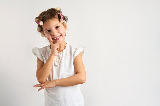 Little girl with curlers on white background