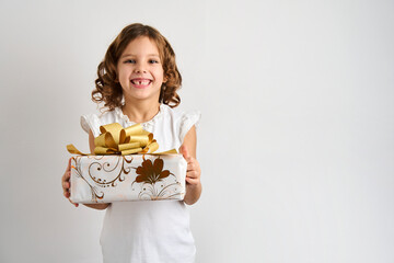 Little girl holding gift box on a white background