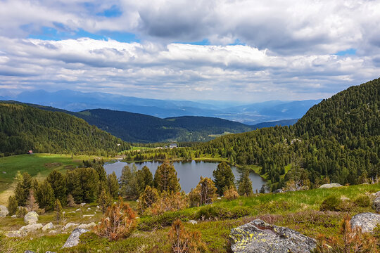 Panoramic view of alpine lake Winterleitensee surrounded by fir forest near Zirbitzkogel, Seetal Alps, Styria (Steiermark), Austria, Europe. Idyllic hiking trails in summer over alpine green pastures
