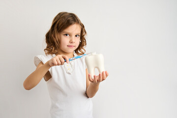 Little girl brushing teeth, white background