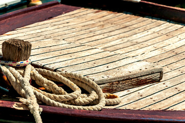 Details of wooden boat bow with forward hatch and some rope