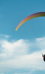 Partial shot of paraglider in the beautiful blue sky with clouds.