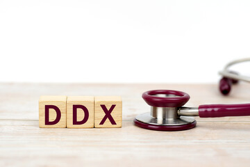 Word DDX (Differential diagnosis ) on wooden blocks and stethoscope on white background. Medical,...