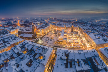 Snow covered old town in Krakow with a view of the Christmas Market photographed in the blue hour.