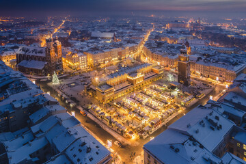 Fototapeta Snow covered old town in Krakow with a view of the Christmas Market photographed in the blue hour. obraz