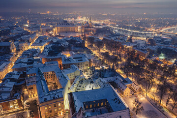 Snow covered old town in Krakow with a view of the Christmas Market photographed in the blue hour.