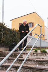Obraz na płótnie Canvas mature man rap singer posing on stairs outdoors on the outskirts of a city