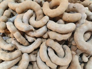 Image of tamarind pods piled up on the floor waiting to be sold