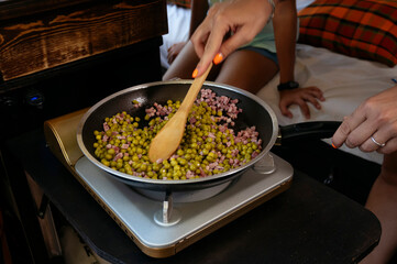 The mother prepares the food on a wonderful day at camp. Van life concept.