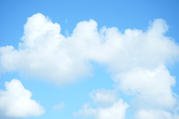 the beauty of white clouds in the blue sky behind green trees during the day