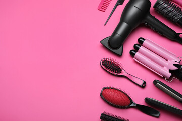 Flat lay composition of professional hairdresser tools on pink background, space for text