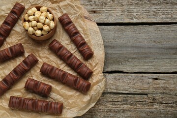 Tasty chocolate bars on wooden table, top view. Space for text