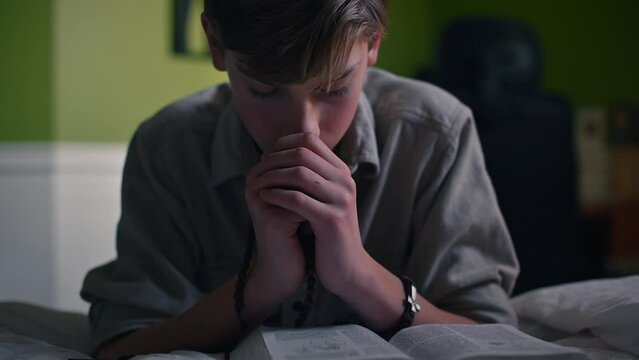 Boy praying by his bed
