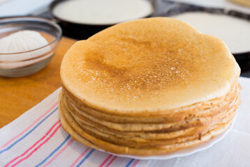 stack of appetizing flour pancakes in the kitchen during cooking