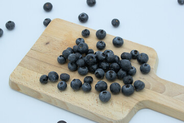 Blueberries on a wooden board with white background