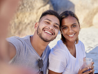 Fototapeta premium Selfie, couple of friends and drinks at beach in summer, party and relax holiday for love, care or happiness. Portrait, young man and smile woman taking photo in sunshine, picnic or happy date at sea
