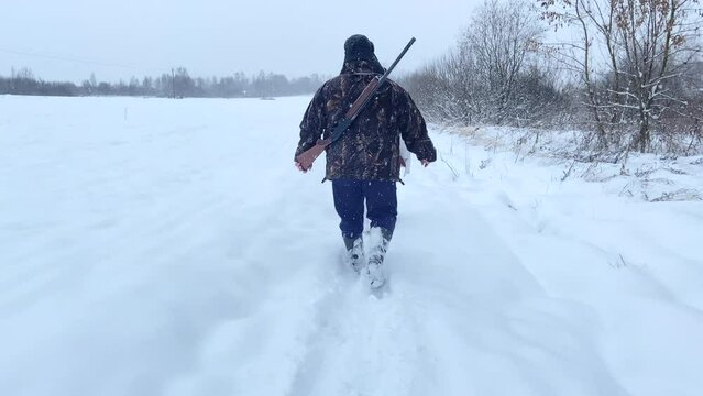 Hunter during hunting in forest. Hunter while hunting wild animals. Hunters with gun and rifle on hunting in winter season. Hunters track down a wild boar or elk in the forest. 