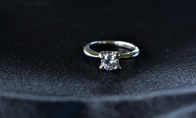 Diamond ring, white gold set with diamonds, placed on the floor.
