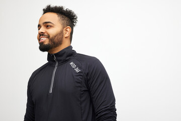 Portrait of attractive young sporty man in training clothing standing isolated on white background. Sportsman having fun. Workout sport fit body concept.