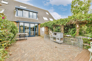 a house with an outdoor patio and garden area in the fore - image is taken from outside, looking...