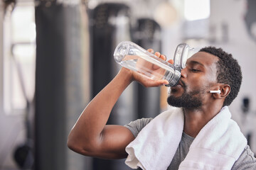 Obraz na płótnie Canvas Water bottle, tired black man in gym and resting after fitness workout, healthy sports exercise and muscle growth training. Rest, motivation and thirsty athlete drinking water for hydration wellness