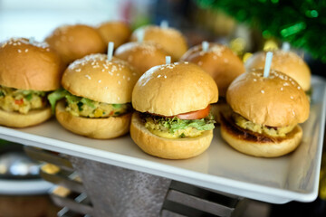 Close-up of appetizer snacks mini burgers on a white plate