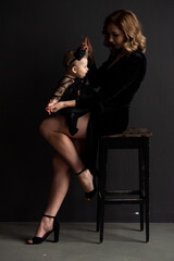 Fototapeta na wymiar Beautiful young woman mother of little baby on dark background