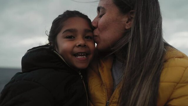 Happy Latin mother having a tender moment with her child during winter holidays - Family and love concept