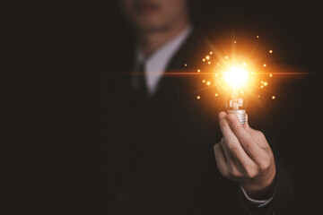 Businessman hand hold Virtual lightbulb. New ideas inspiration and innovation technology concept. Science and communication concept.