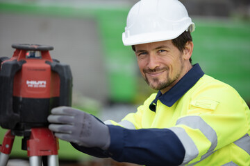 portrait of surveyor next to theodolite machine