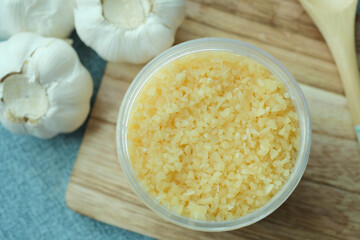 close up of minced garlic on a wooden spoon 