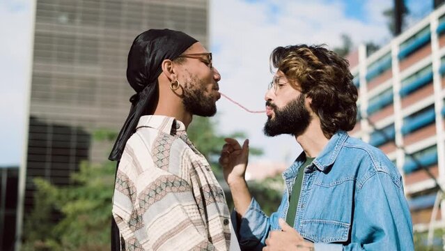 Gay couple playing with candy in the street