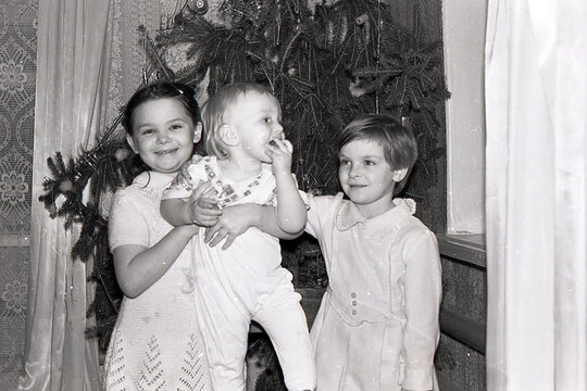 old scanned black and white photo from the family archive, families near the Christmas tree
