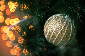 photos of Christmas balls on the Christmas tree, the color of the New Year's decoration in golden tones, a garland and a festive bokeh. space for text. New Year greeting card, selective focus.