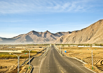 The straight road runs through the hot desert.