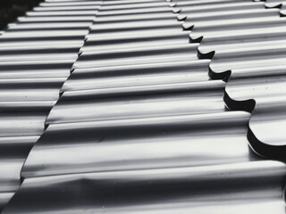 Gray wave profile metal tile on the roof of the house close-up