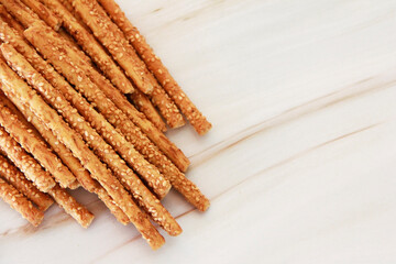 Long dry sesame bread sticks on a gray marble background