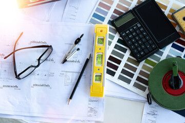 Architect concept, Architects working with blueprints in the office Business accessories (laptop, smartphone, pens, magnifier), accessories for drawing (plans, rulers) and learning on the table