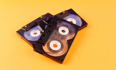 Three audio cassettes on an orange background
