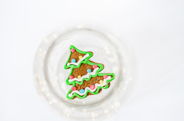 Christmas tree gingerbread cookie in glass container on white backgound