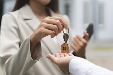 Close up view realtor broker holding home keychain in her hand.