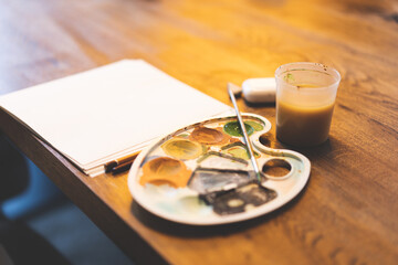 Artistic brush of mixed colors of gouache painting on a palette. Macro artist's palette. Palette with a brush. The artist paints a picture with gouache paints. Artistic palette