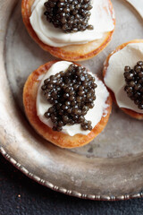Black caviar and appetizers mini pancakes top view