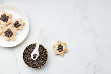 Black caviar appetizers bread star on a white background top view